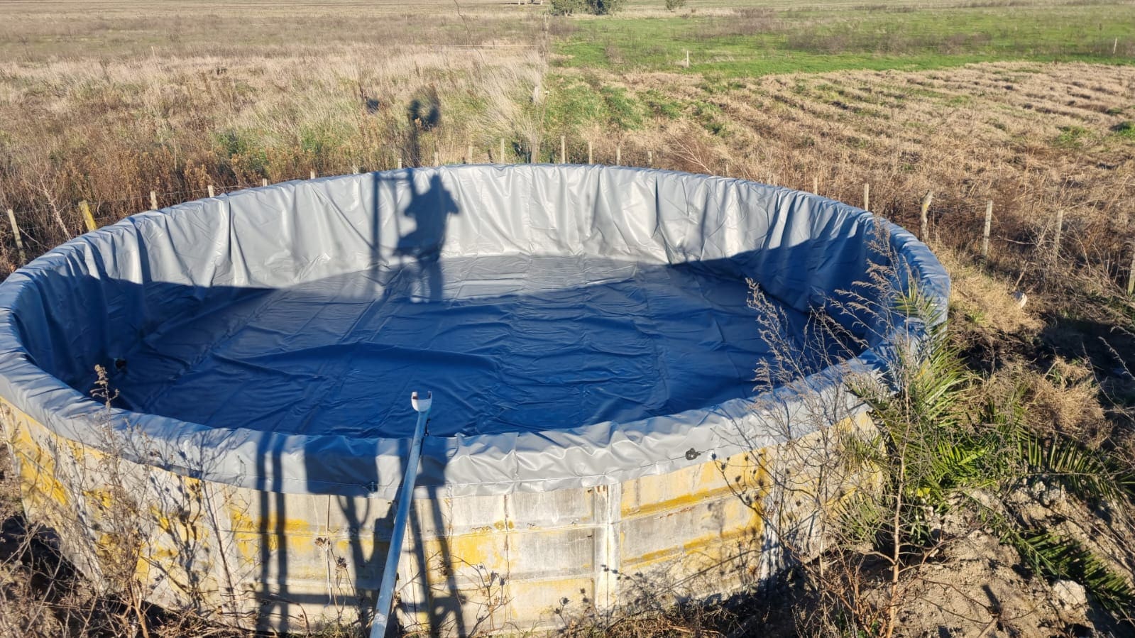 Funda gris para tanque australiano instalada en el campo